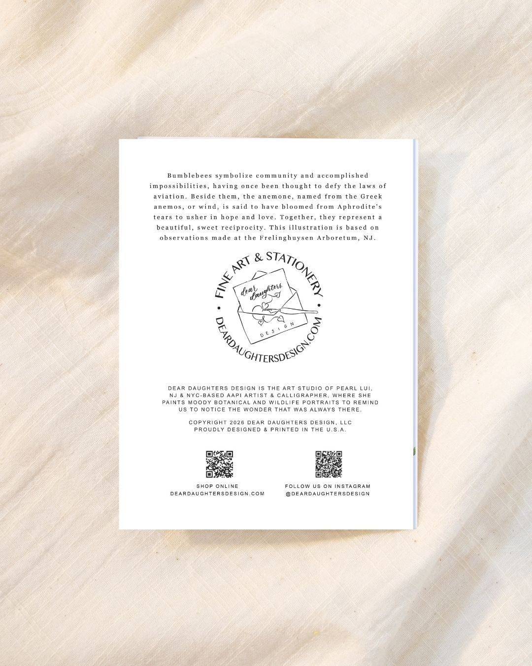 A rectangular white art print or card with black text and a circular logo reading 'Fine Art & Stationery' placed on a light beige marble-like surface.