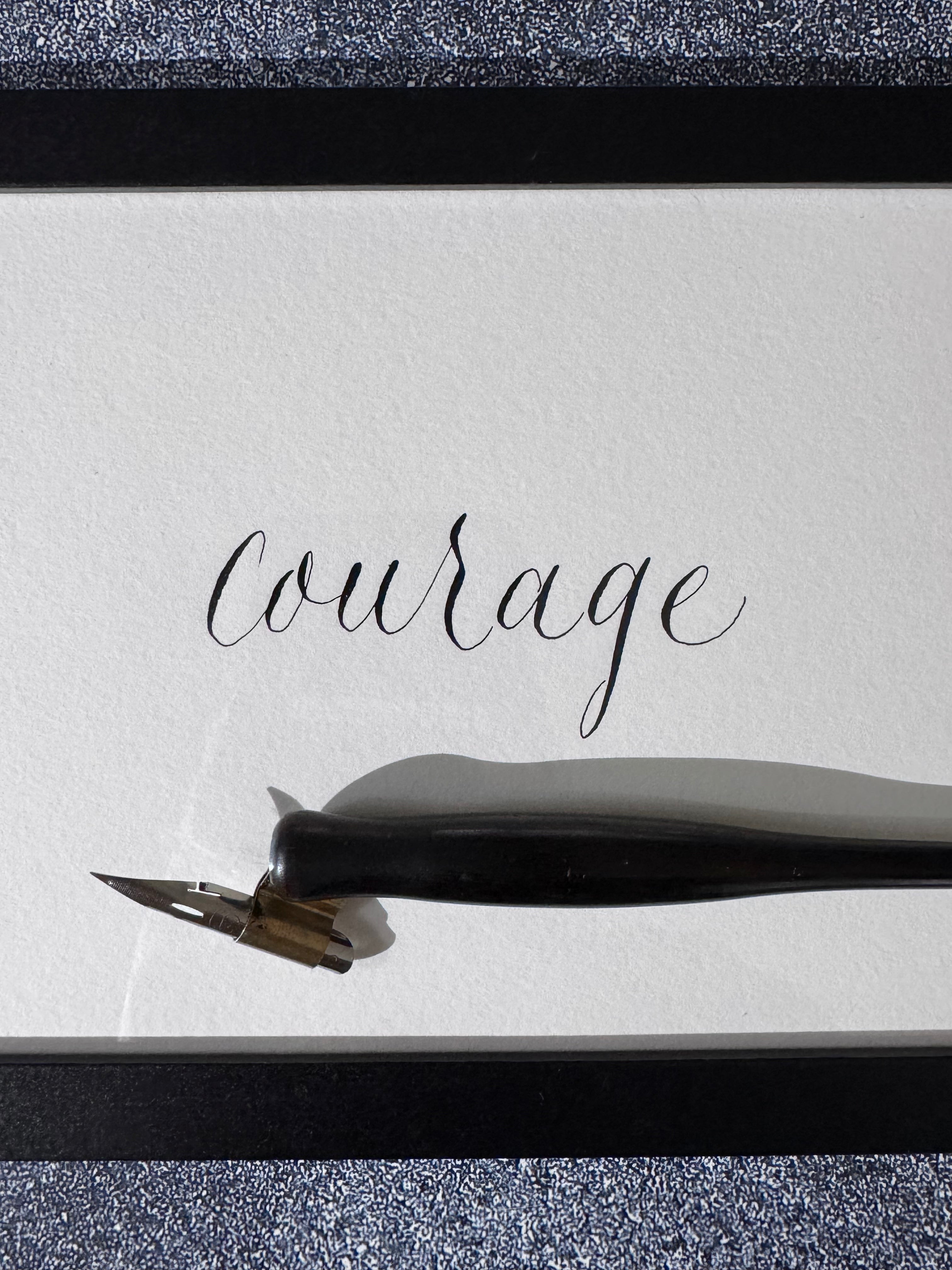 Ink pen with 'Courage' written on a piece of paper